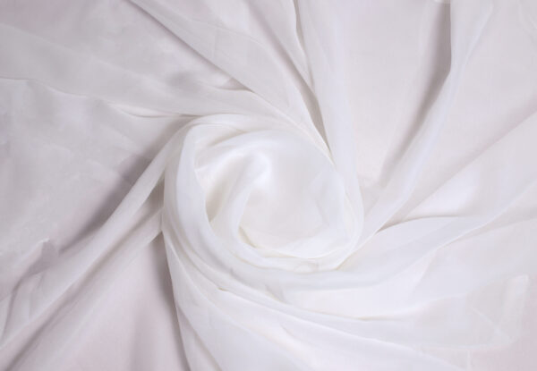 "Elegant georgette fabric draped gracefully, showcasing its lightweight, sheer texture with soft folds and a delicate flow."